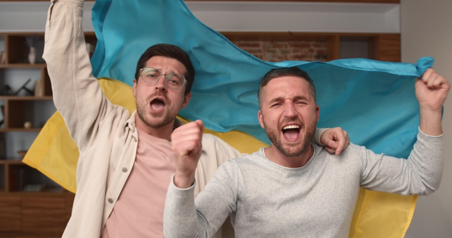 Male friends cheering for Ukrainian football team