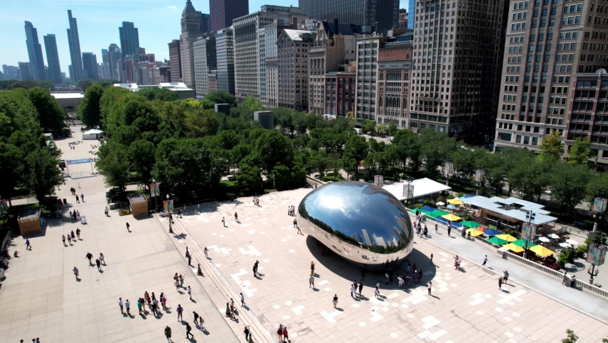 Orbital aerial view of Cloud gate sculpture at Millennium park with Chicago cityscape in background. Royalty-Free Stock Footage #1097076321