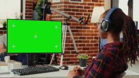 Female manager analyzing greenscreen template on monitor, working with isolated mock up background at desk. Using blank chroma key display with copy space on personal computer at home.