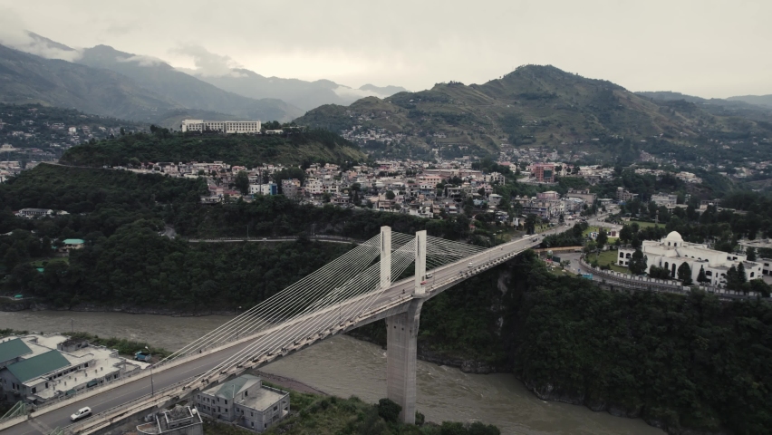 A view of Muzaffarabad Kashmir with mountains and clouds in the background and Nalochi Bridge also known as Benazir Bhutto Bridge Muzaffarabad. Capital City of Azad Kashmir - Buildings and cityscape