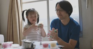 4K Video Slow motion father and daughter play light clay in living room. Video concept for family and connection time.