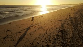 Aerial shot of a Athletic African American Man jogging on the beach at sunset - Powered by Shutterstock - Get 15% off with code: PIKWIZARD15