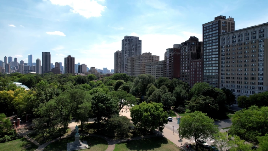 Sliding aerial view of Chicago skyline around Garfield park Conservatory, on bright sunny day.