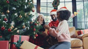 Joyful happy African American family decorating Christmas tree together in living room for Christmas festive season, enjoy the family together magical moment. - Powered by Shutterstock - Get 15% off with code: PIKWIZARD15