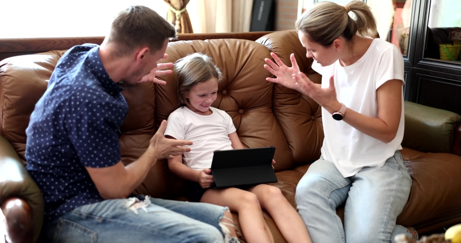 Parents on the couch shout at a child with a tablet Royalty-Free Stock Footage #1097101705