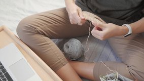 Close-up video of woman crocheting bag of polyester cord. Anti-stress hobby. Tranquil leisure at home. Handicraft. Online lessons for amateurs on laptop.