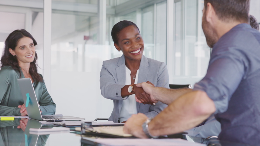 Happy black businesswoman and businessman shaking hands at meeting. Professional business executive leaders making handshake agreement. Happy business man closing deal at negotiations. Royalty-Free Stock Footage #1097113139