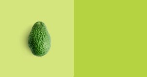 Creative animation made of avocado full an peeled on the green background. Animation concept food. 