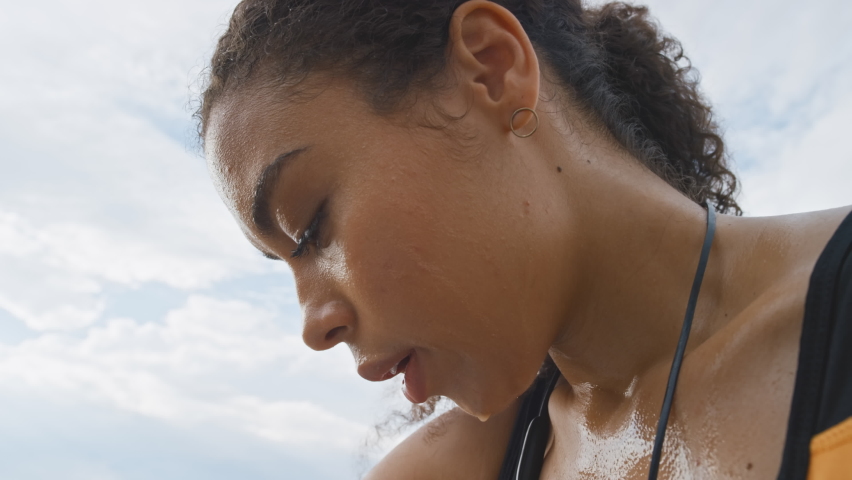 Face, sweat and fitness with a sports woman breathing while feeling tired after an exercise or workout. Exhausted, sweating and thinking with a female employee out of breath during cardio training Royalty-Free Stock Footage #1097118443