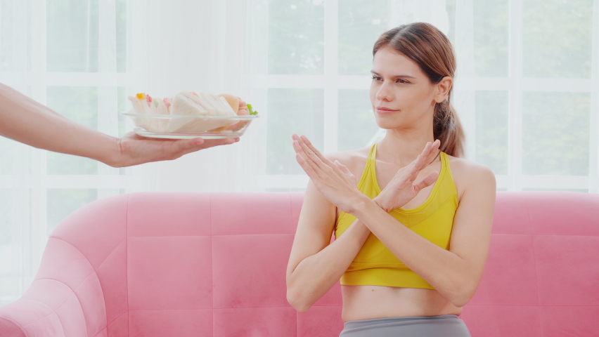Hands serving food and young caucasian woman making sign say no food unhealthy with obese, woman refuse and push out food with temptation for dieting, nutrition and fast food a bad, health concepts.