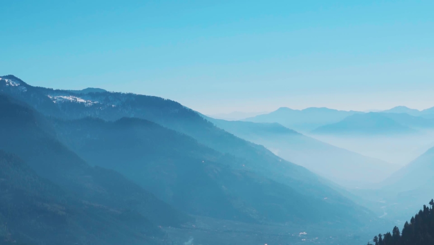 Foggy mountain layers as seen from above the mountains during the Rani Sui Trek near Manali in Himachal Pradesh, India. Natural mountain background. Himalayas covered by the fog during the morning.  | Shutterstock HD Video #1097123413