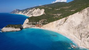 Aerial drone video of popular paradise deep turquoise beach of Porto Katsiki with white steep rocky seascape and beautiful cloudy landscape, Lefkada island, Ionian, Greece