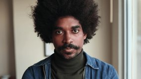 Portrait of a man with African American and Indian characteristics touching his frizzy curly hair