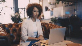 African American woman having online call in cafe, remote work, freelancer