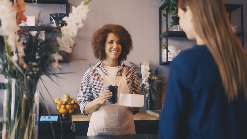 Smiling woman giving coffee and cake to-go to client in cafeteria, good service - Powered by Shutterstock - Get 15% off with code: PIKWIZARD15