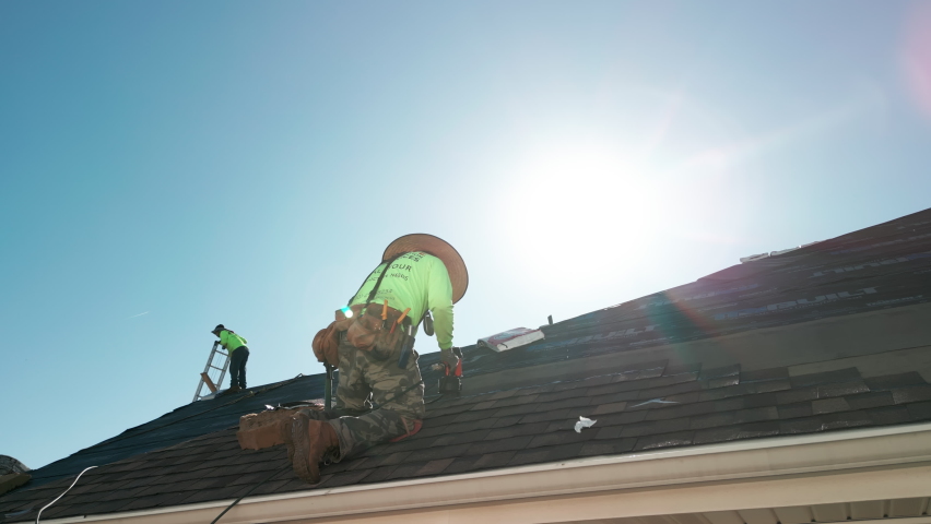 Close up view of Roofer repair or replace shingle that has been damaged and needing replacement at sunny day.  Royalty-Free Stock Footage #1097129159
