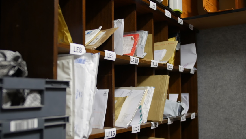 A post office mail room and sorting office with letters and shelving Royalty-Free Stock Footage #1097130501