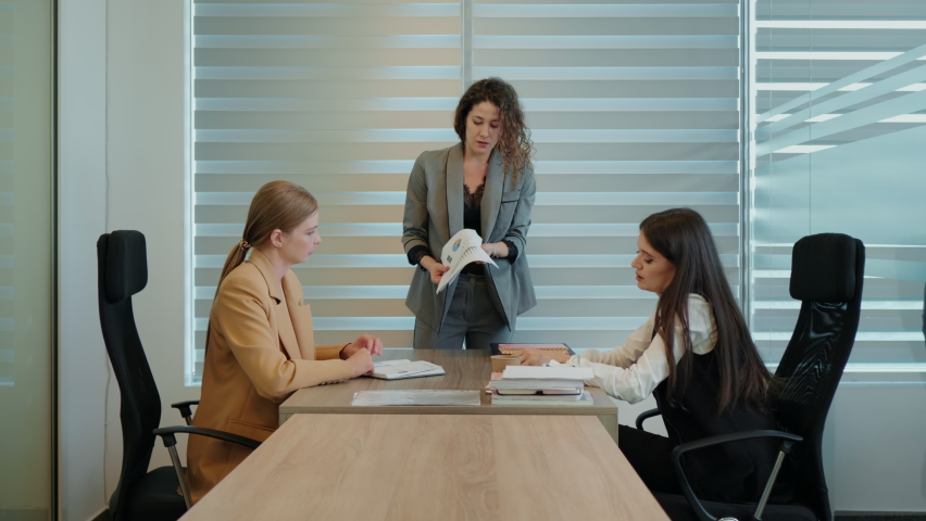 Team work trouble. Workplace bullying business woman unsatisfied with work throwing papers and pointing with her fingers. | Shutterstock HD Video #1097135081