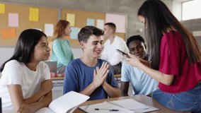 Group of multi-ethnic students chatting after lecture in classroom. High school classmates talking while sitting together in class during a break - Powered by Shutterstock - Get 15% off with code: PIKWIZARD15