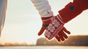 Back view of couple holding hands wearing gloves at winter sunset. Happy couple dating at sunny day outside at Christmas holidays. spend time together at Christmas eve. Girl and a guy have fun laugh - Powered by Shutterstock - Get 15% off with code: PIKWIZARD15