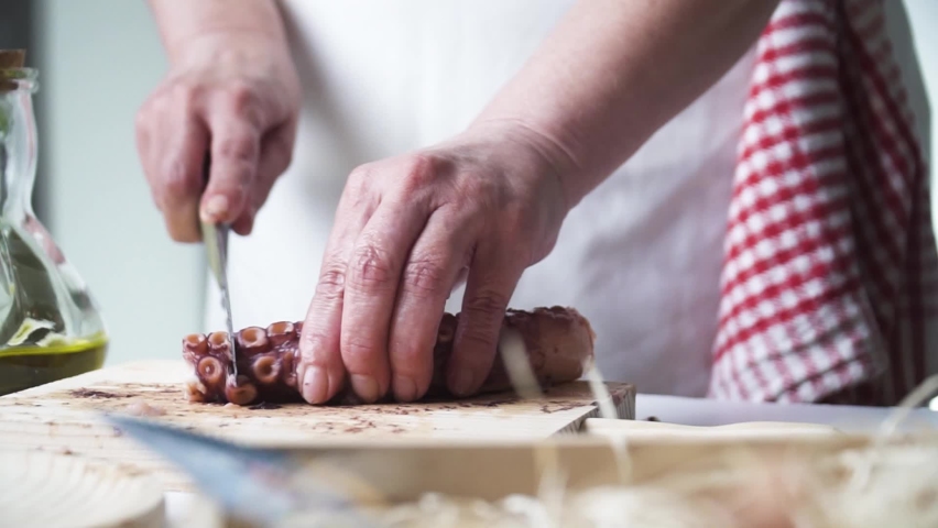Close up shot of a person hands cutting and preparing the octopus