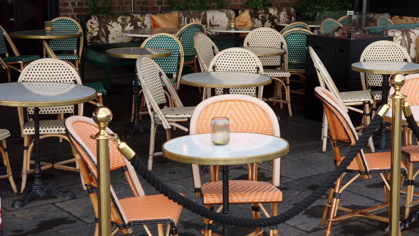 Sidewalk cafe  with small round tables and empty chairs - coffeehouse, coffee shop, diner or restaurant.