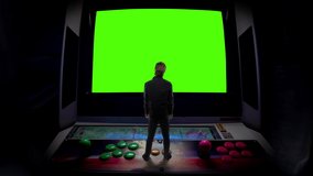 Retro Arcade Game Man Standing Old Console Green Screen. Man standing on top of an old arcade video game green screen. Surreal Scene