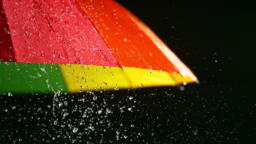 Rain drops on colored umbrella, super slow motion filmed on high speed cinematic camera