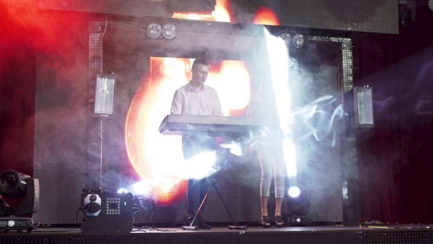 Musicians Duet performans on stage with piano and background interactive board