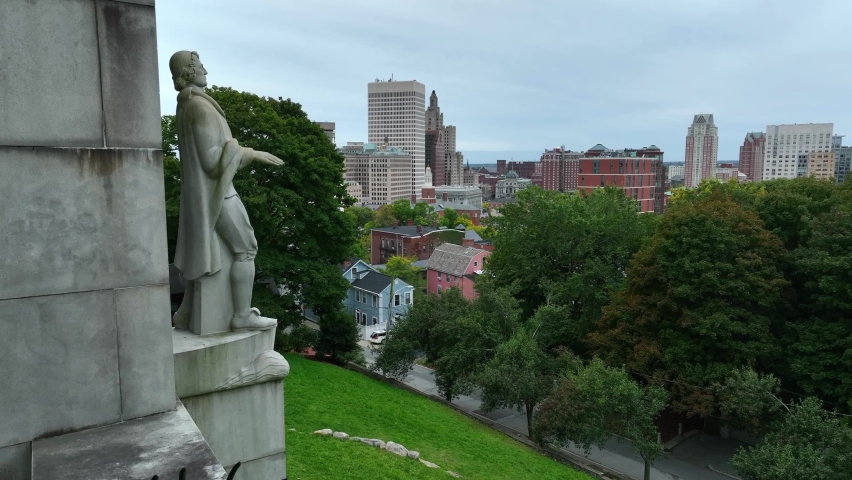 Providence Rhode Island skyline from Prospect Terrace Park. Statue of Roger Williams, founder of city. Rising aerial reveal shot of downtown cityscape.