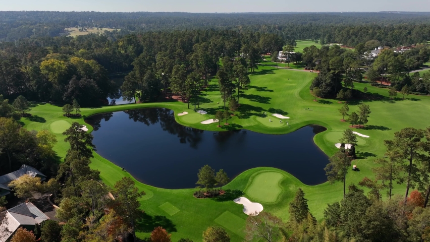 Spruce pine trees at Augusta National Golf Club in Georgia. Aerial view of water hazard and sandtraps on fairway greens. Royalty-Free Stock Footage #1097157959