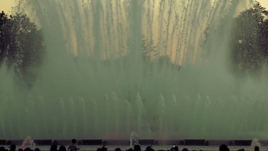Day Shot Before Sunset Of Performance Of Singing Magic Fountain Of Montjuic In Barcelona, Catalonia, Spain. In Foreground Silhouettes of People. High quality 4k footage