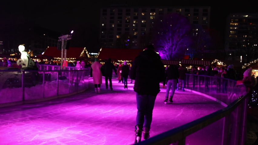 ice skates, Christmas Eve, skate romantic, Ice skating on ice rink in evening, people in winter clothes, practicing skating on ice skate ring decorated with lights, in europe, enjoying 