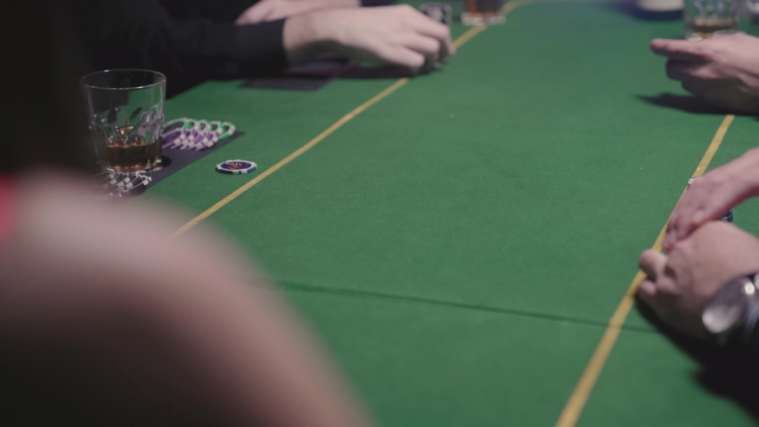 Several men play poker in a casino for luck and money. Gambling and alcohol addiction. Recreational gambling.