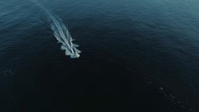 Aerial view, 4k drone shots, tracking boat. Motor boat sailing in blue sea at sunrise in summer