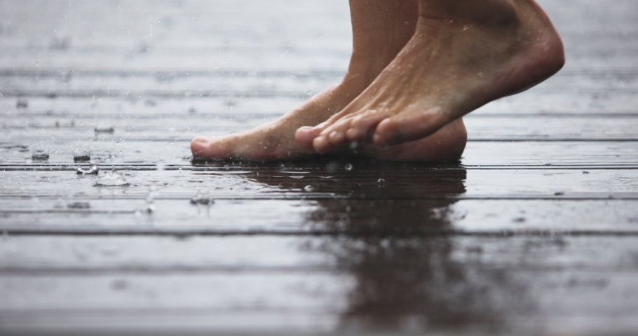  Women's Feet Jump in an Autumn Puddle on a Wooden Floor Wet from the Rain. Close up Light Skin Caucasian Girl Barefoot Stomp and Playing on Puddles on the Raining Day, Fun Time. Happiness concept. | Shutterstock HD Video #1097180399