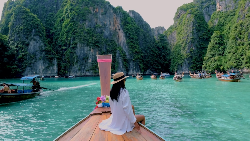 Pileh Lagoon with the green emerald ocean at Koh Phi Phi Thailand, women in front of a longtail boat | Shutterstock HD Video #1097182141