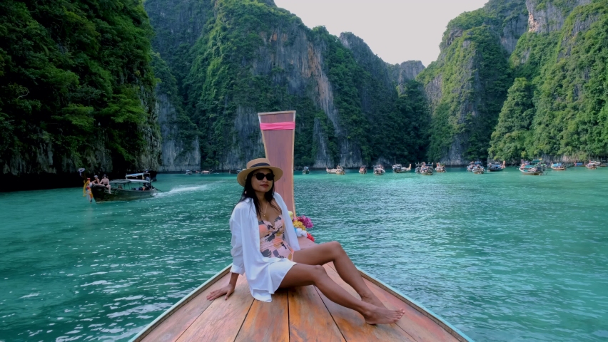 Pileh Lagoon with the green emerald ocean at Koh Phi Phi Thailand, women in front of a longtail boat | Shutterstock HD Video #1097182143