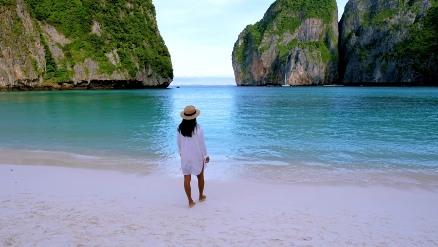 Women with a hat walking on the beach at Koh Phi Phi Thailand at Maya Bay the famous beach in Thailand | Shutterstock HD Video #1097182285