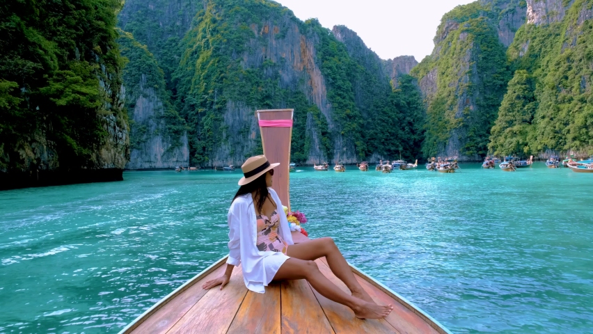 Thai women in front of longtail boat at Pileh Lagoon with the green emerald ocean at Koh Phi Phi Thailand,  | Shutterstock HD Video #1097182311