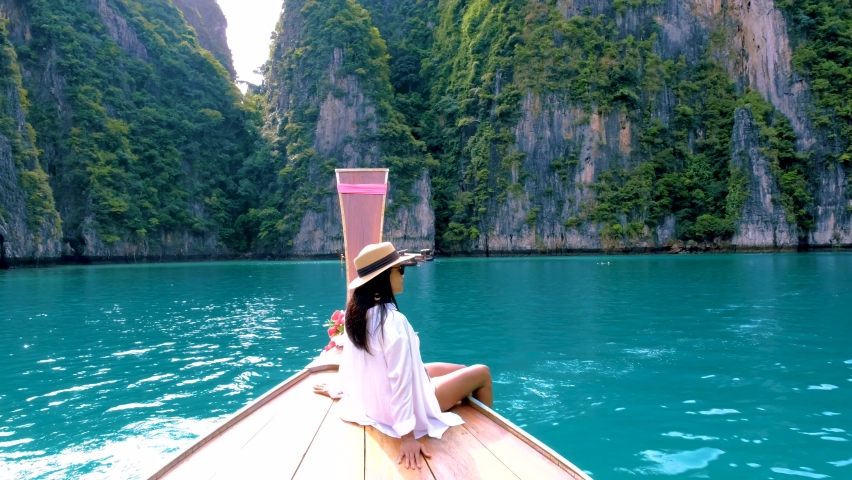 Pileh Lagoon with the green emerald ocean at Koh Phi Phi Thailand, Thai Asian women in front of longtail boat | Shutterstock HD Video #1097182317