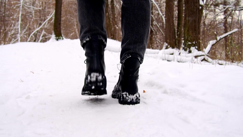 The feet of a man walking in the snow. A walk in a winter forest. The concept of mental health. | Shutterstock HD Video #1097183907