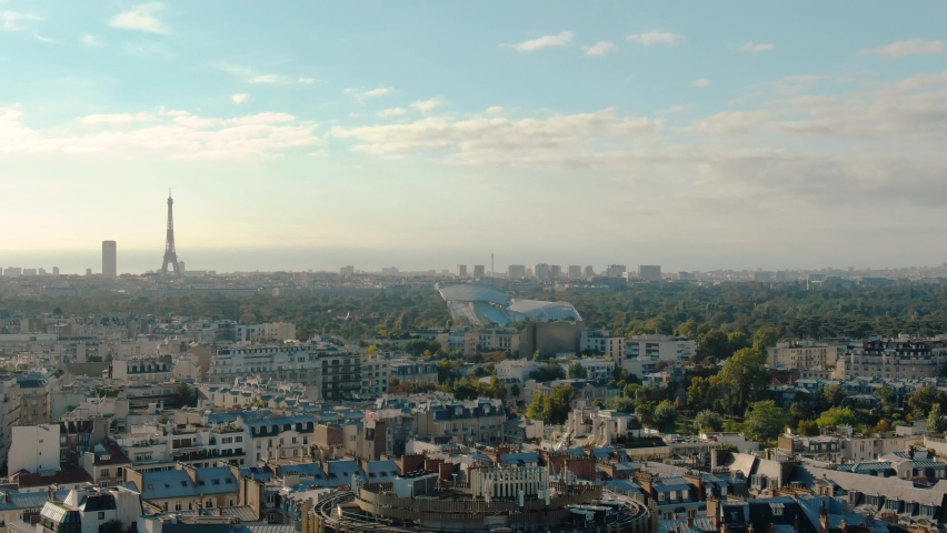 Aerial view of the paris cityscape showing residential buildings and the iconic eiffel tower under a clear sky