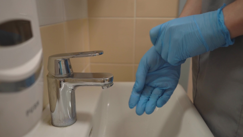 The doctor takes off his medical gloves to wash his hands. High-quality shooting in 4k format | Shutterstock HD Video #1097193165