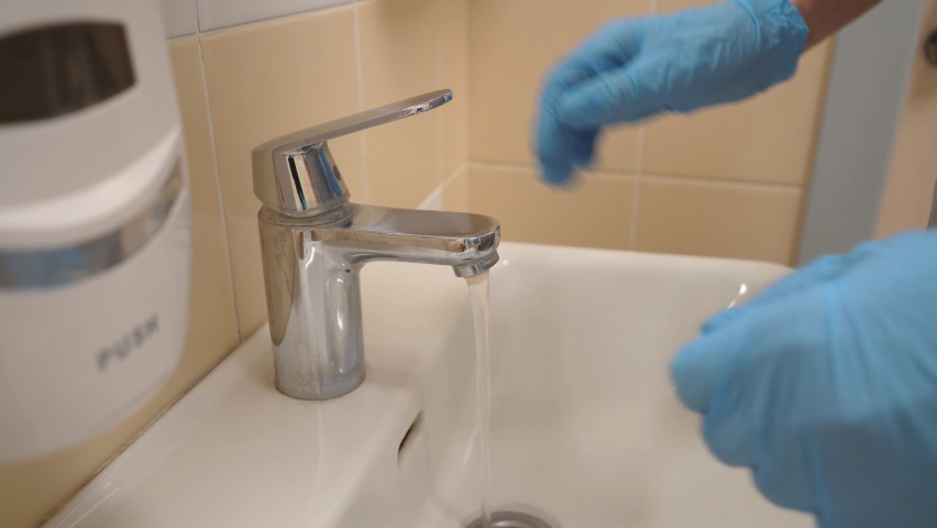 The doctor washes his hands while wearing gloves. High-quality shooting in 4k format | Shutterstock HD Video #1097193167