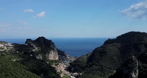 Aerial drone video of tropical paradise exotic landscape in Italy, Napoli, Amalfi coast. Flying over mountains and little village nearby the sea. Luxury yachts and sailboats in the sea. Harboring. 
