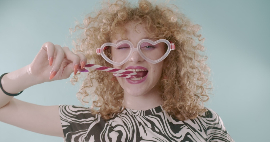 Sweet girl is playing with the candy cone while having some crazy glasses | Shutterstock HD Video #1097198535