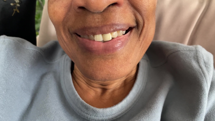 Smiling face of an unrecognizable Black elderly person in a grey sweater | Shutterstock HD Video #1097205633