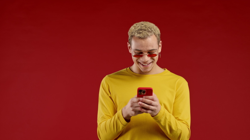 Handsome trendy man received sweet message on mobile phone. Guy with surprise and joy. Technology, success, happiness concept. | Shutterstock HD Video #1097208051