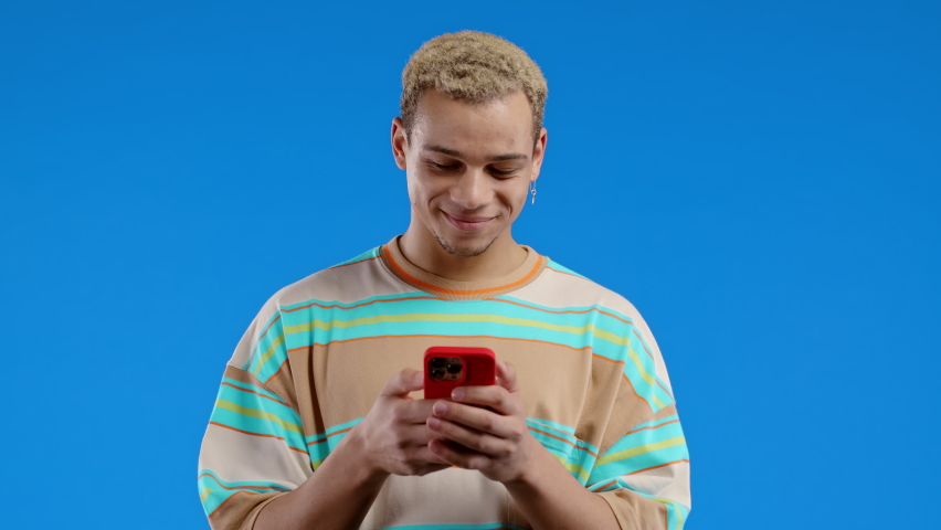 Handsome man receives happy notification or message on mobile phone. Guy with surprise and joy. He won and rejoices. Technology, success, happiness concept. | Shutterstock HD Video #1097208059
